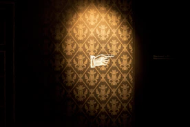 Close-up of a hands installing exquisite patterned wallpaper in a bright room.