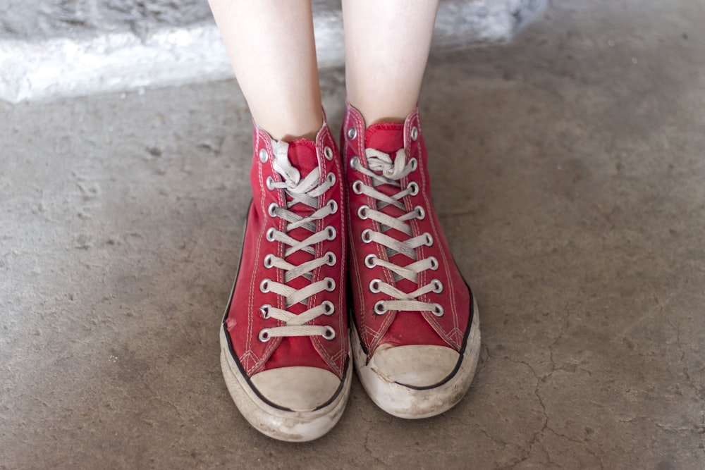 Persona que lleva zapatillas rojas de caña alta