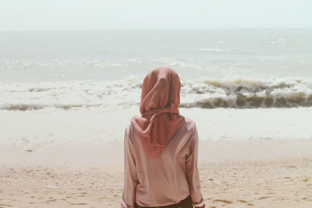 海の波の前の浜辺に座っている女性