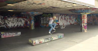 Skater performing a kickflip with vibrant city graffiti in the background.