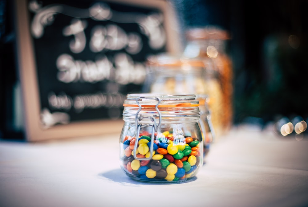 Bonbons ronds dans un bocal en verre transparent avec couvercle à pince