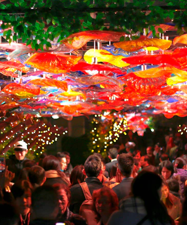 A vibrant party setup featuring colorful decorations, cozy furniture, and a lively inflatable in the background.