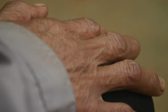 Close-up of hands holding a Medicare card with a soft-focus background of a home setting.