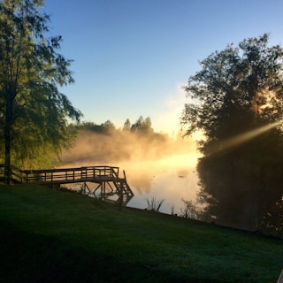 Morning mist rising over a serene lake visible from a private deck at a Tidewater Stays rental.