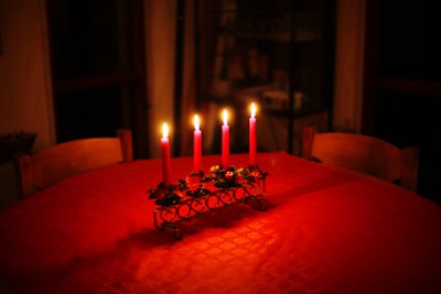 A cozy living room corner featuring seven flames Kwanzaa candles on a modern wooden holder.