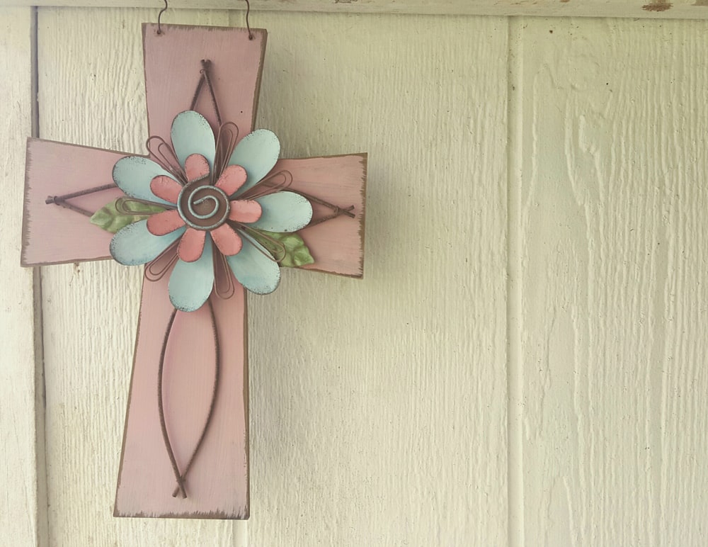 A pink cross with a flower on top.