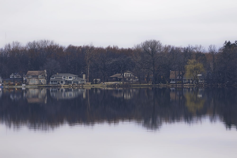 Ferienhäuser auf dem Wasser mitten im Wald, perfekt vom See reflektiert.