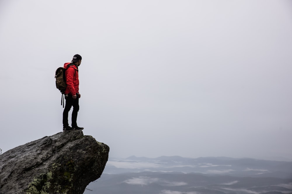 person standing on gray rock