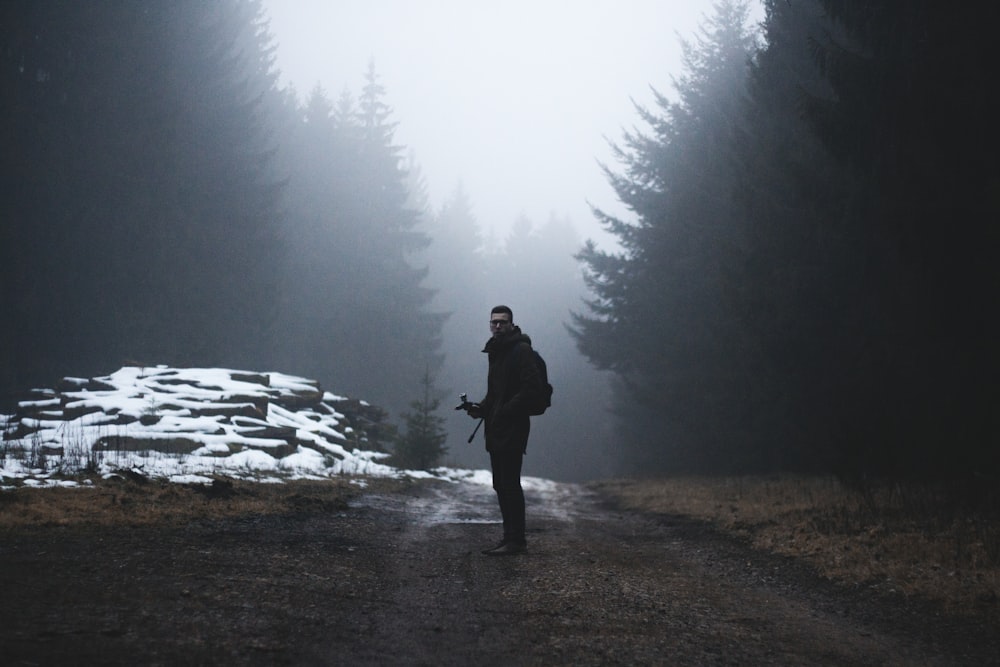 man standing on a wet road