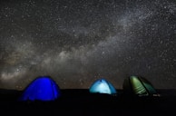 Traditional Berber tents set up under a starry night sky in the desert.