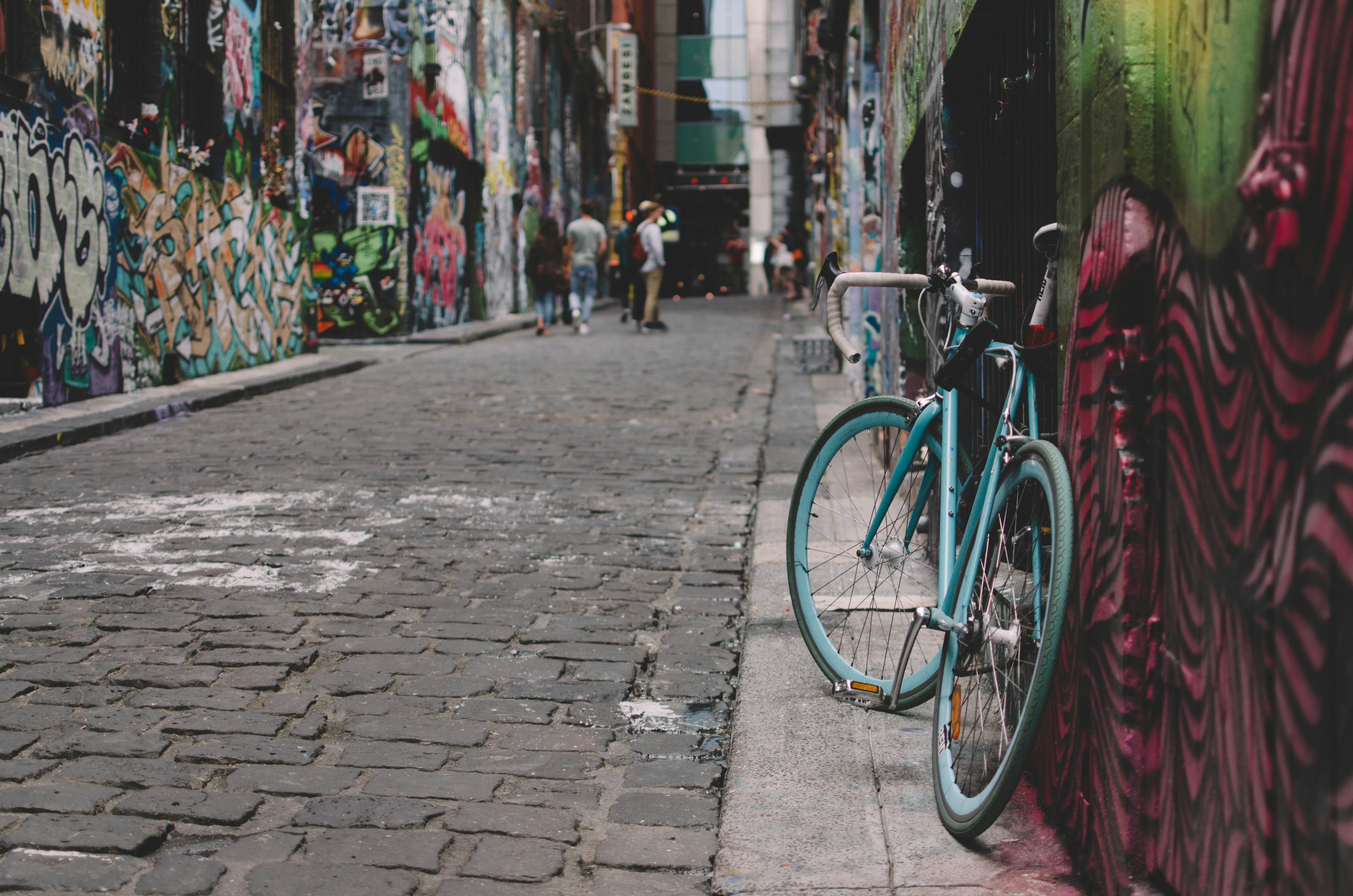 black and blue full-suspension bike parked beside wall, Hosier Lane graffiti