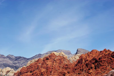 Close-up of hands exchanging business cards with a backdrop of the red sandstone landscape.
