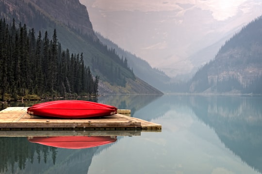 brown floater with red canoe in body of water in Banff National Park Canada