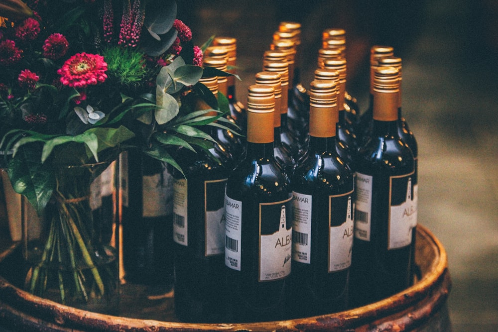 black glass bottles on round table with flowers