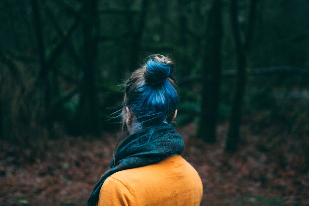 Frau in braunem Oberteil mitten im Wald