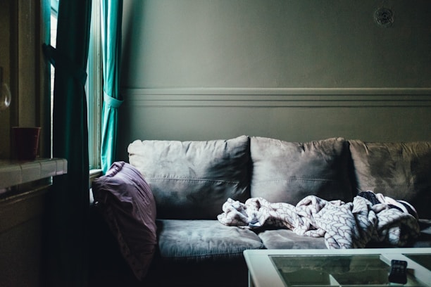 A cozy living room featuring a soft blanket draped over a comfortable sofa.