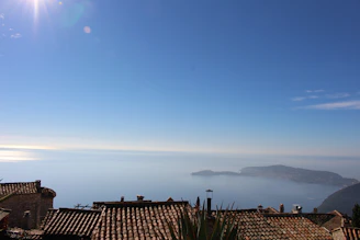 A serene view of the Italian Riviera coastline at sunrise, with calm blue waters and terracotta rooftops.