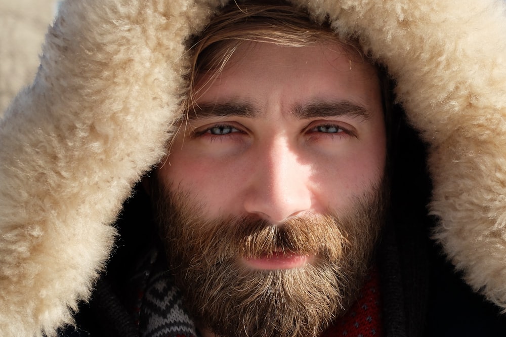 man covered by beige fur textile