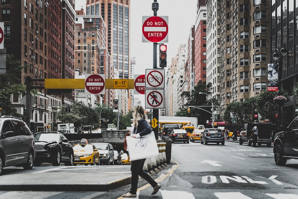 woman walking on road near cars