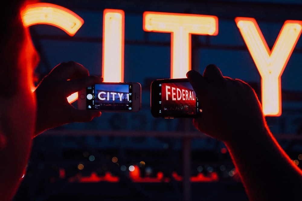 minimalist photography of person taking pictures of City Federal signages