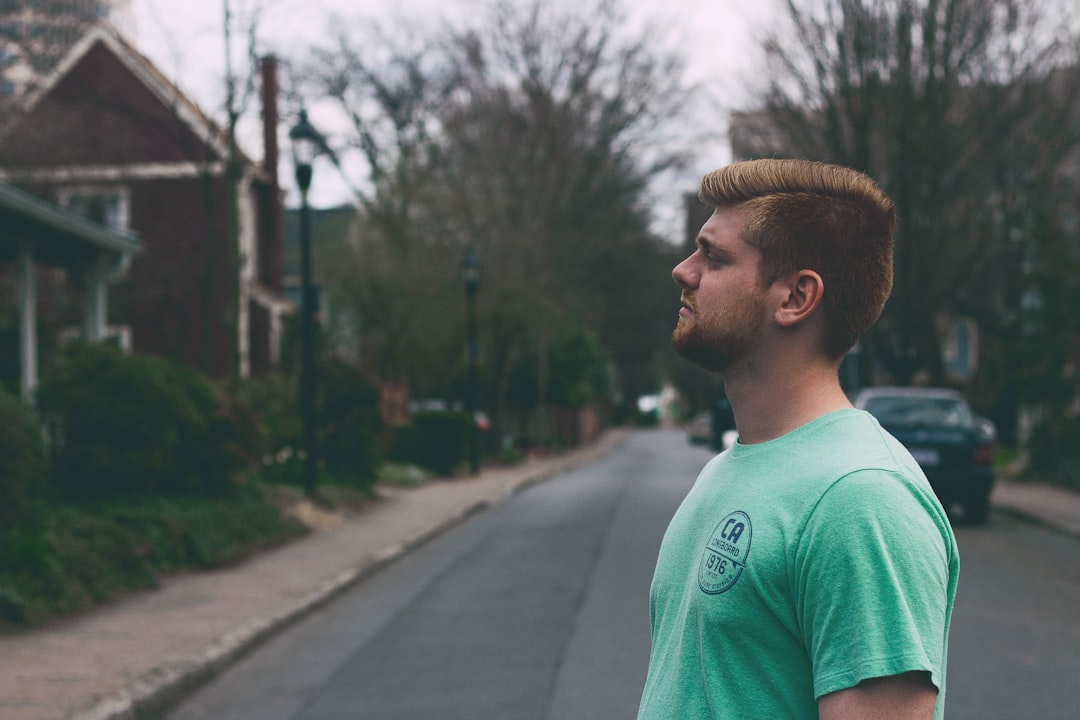 man standing in middle of road at daytime