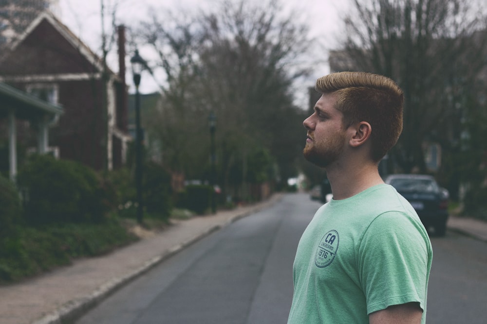 man standing in middle of road at daytime