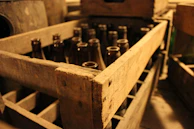 A rustic wooden crate filled with assorted Jeje Fresh Milk bottles in different sizes.