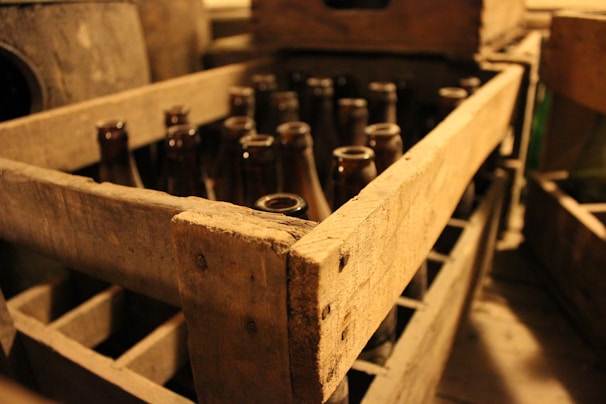 A rustic wooden crate filled with various craft beers and mixers.