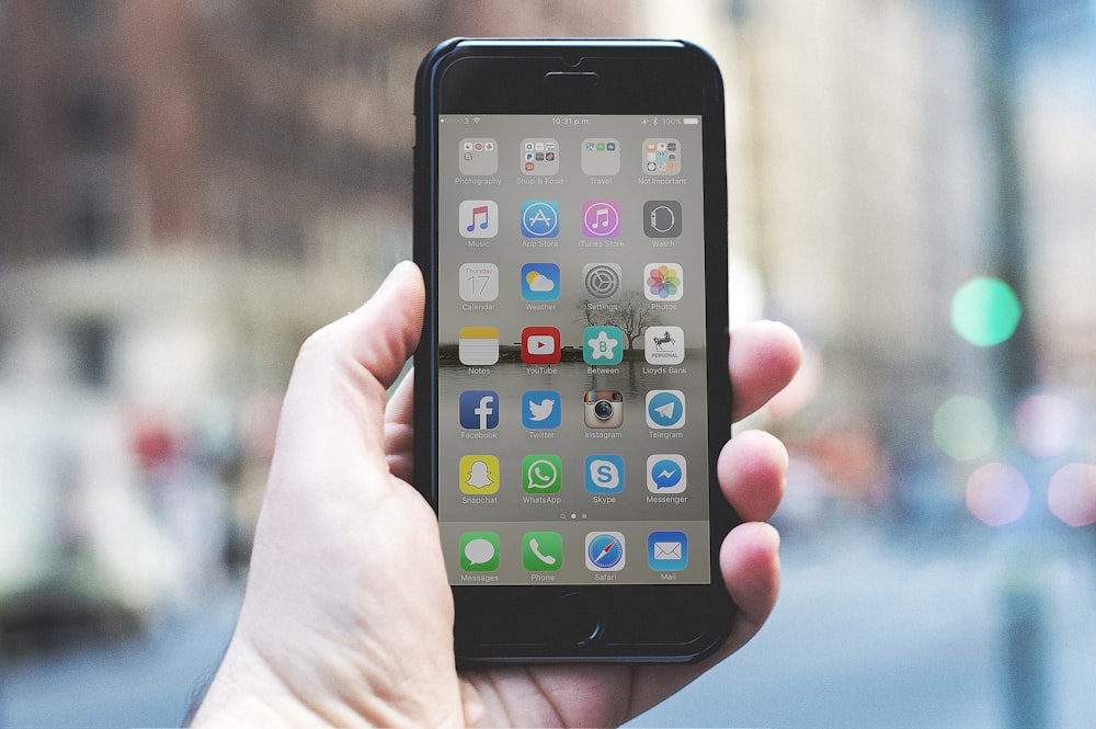 person holding a space gray iPhone 6 and black case