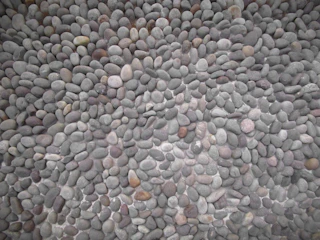 Artistic arrangement of stones and gravel creating depth and texture in a garden.