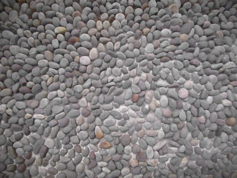 Artistic arrangement of stones and gravel creating depth and texture in a garden.