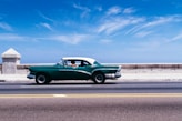 green coupe on gray asphalt road