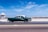 green coupe on gray asphalt road