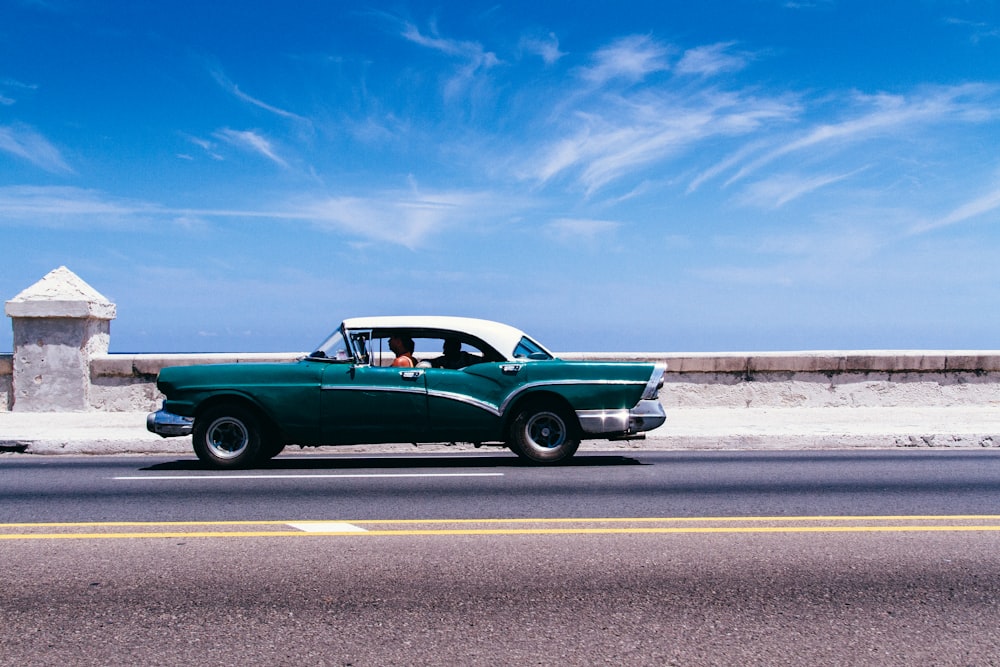 green coupe on gray asphalt road