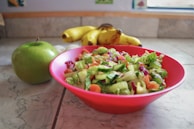 A vibrant salad bowl with fresh ingredients on a clean kitchen counter.