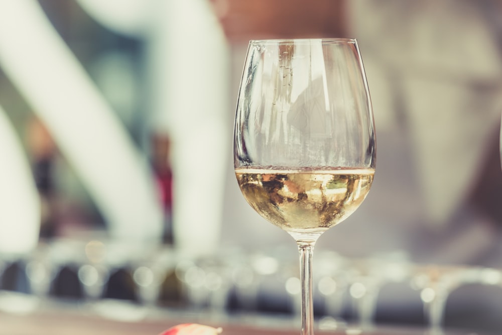 Fotografia a fuoco selettiva di un bicchiere da vino in vetro trasparente