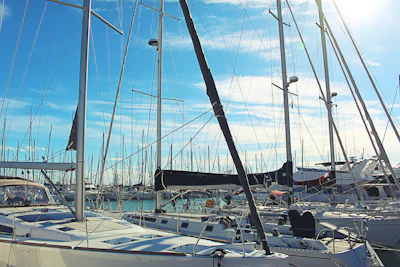 A panoramic view of Herzliya Marina with sailboats lined up under a bright blue sky.