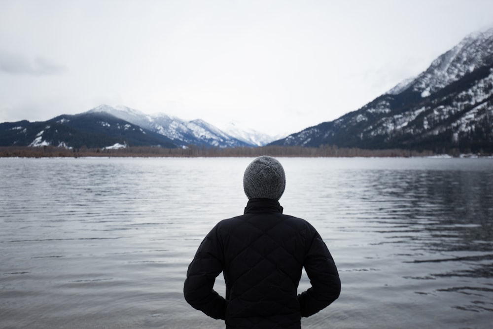 Uomo in top nero in piedi davanti al lago