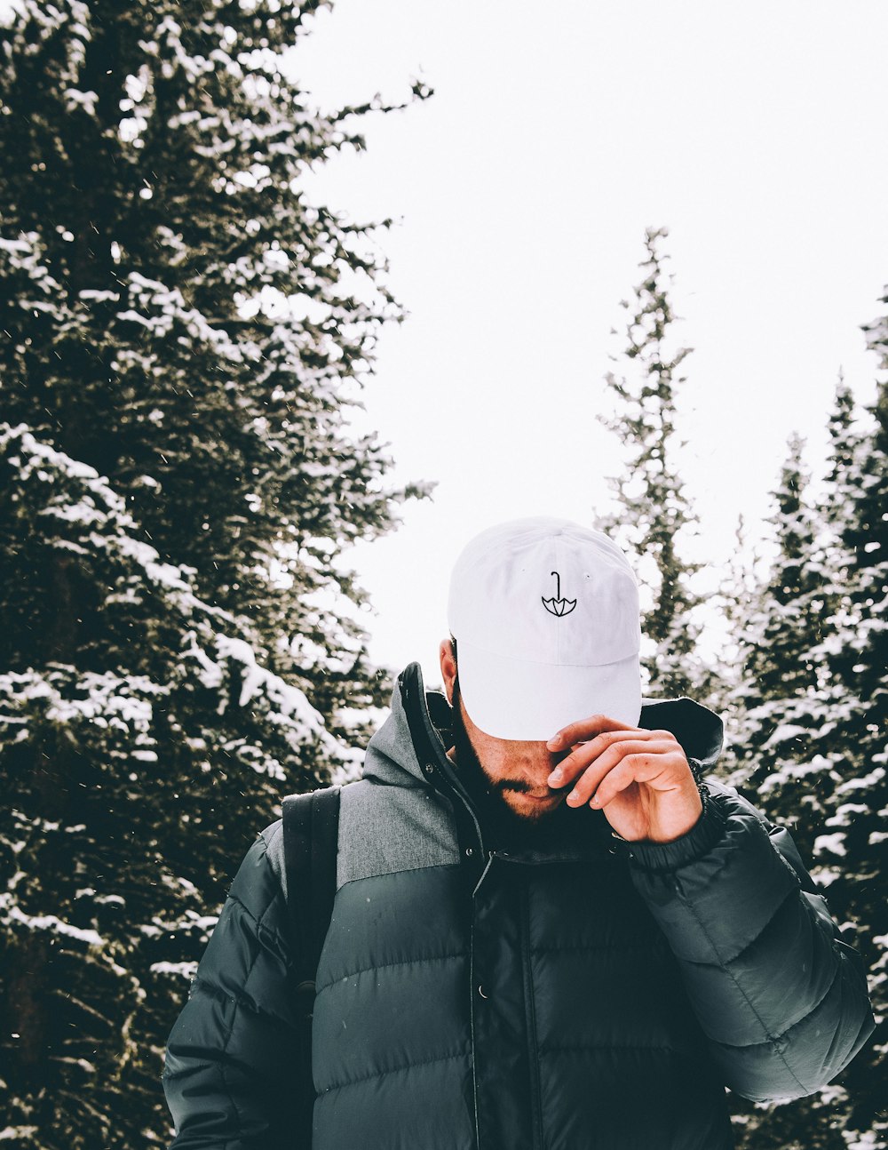 man in black jacket wearing white knit cap