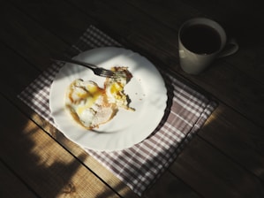 Cozy cafe table with a plate of farmhouse eggs and a steaming cup of coffee bathed in warm natural light.
