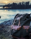 A rugged backpack and camping gear arranged neatly on a forest trail.
