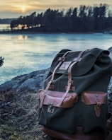 A traveler’s backpack resting beside a scenic mountain trail at sunset