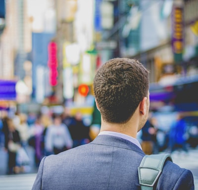 shallow focus photography of man in suit jacket's back