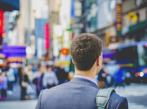 shallow focus photography of man in suit jacket's back