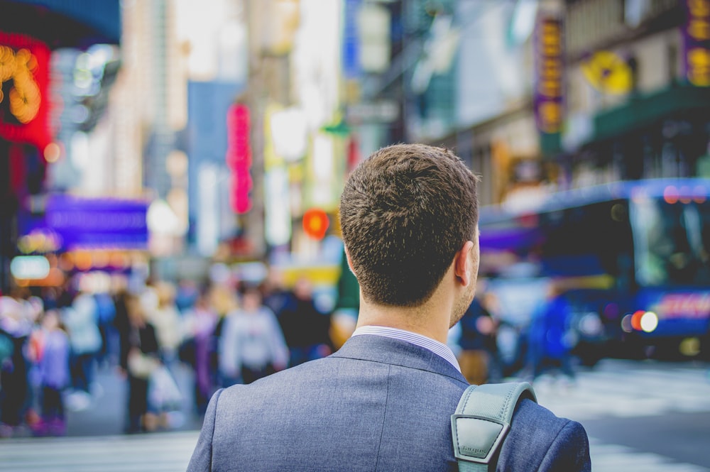 shallow focus photography of man in suit jacket's back