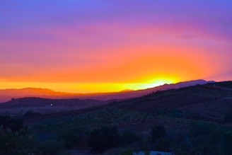 Vibrant landscape showing a sunset over rolling hills.