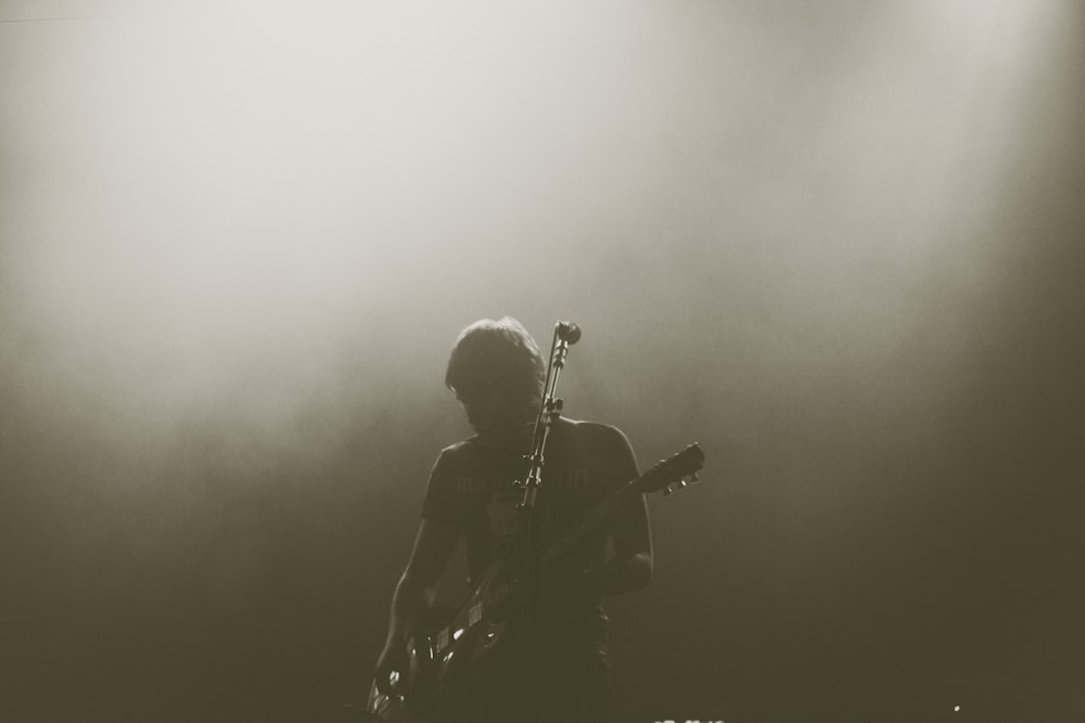 man playing electric guitar on stage