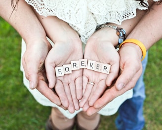 adult and girl holding forever scrabble letters during daytime