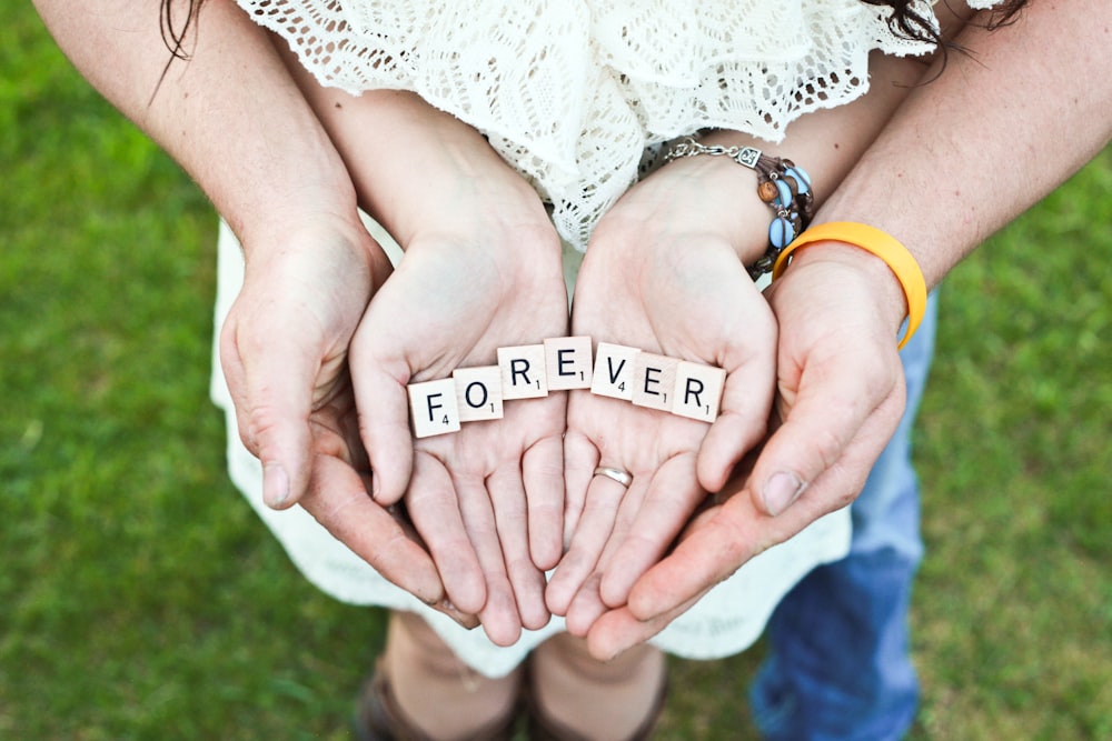 Adult And Girl Holding Forever Scrabble Letters During Daytime