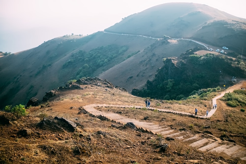 person walking on brown dirt road during daytime